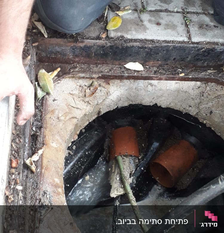 פתח ביוב עם צינורות וכלי עבודה